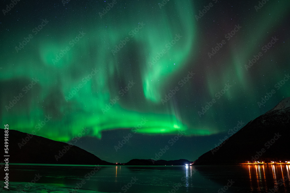 Aurora borealis in the starry night sky over the lake
