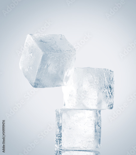 Natural clean ice cubes on white background stacked unbalanced vertically.