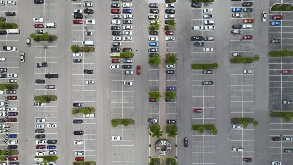 Aerial view of large parking lot with many parked colorful cars. Carpark at supercenter shopping mall with lines and markings for vehicle places and directions Aerial view of large parking lot with many parked colorful cars. Carpark at supercenter shopping mall with lines and markings for vehicle places and directions