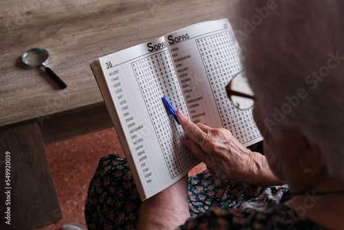 senior woman spending retirement time playing word search at home photo