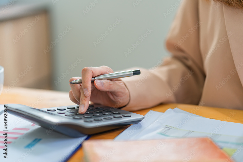 Fototapeta premium Close-up of female accountant or banker making calculations. Savings, finances, and economy concept
