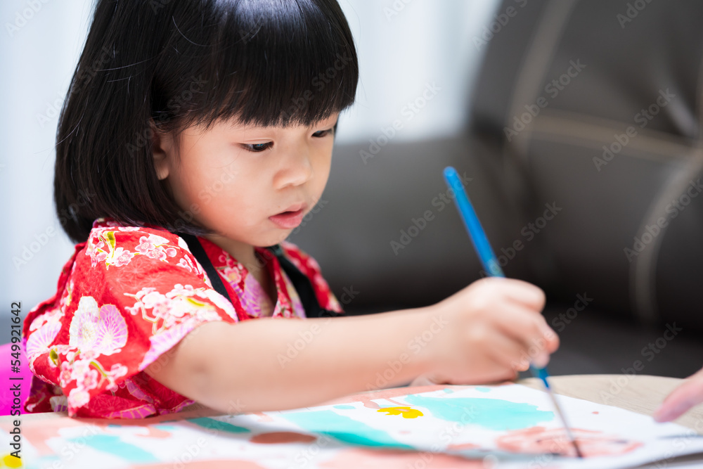 Asian child drawing pictures at home. Beautiful toddler girl painting colorful color on white paper art on table. Lesson homeschool. Children with hobby. Asian child drawing pictures at home. Beautiful toddler girl painting colorful color on white paper art on table. Lesson homeschool. Children with hobby.