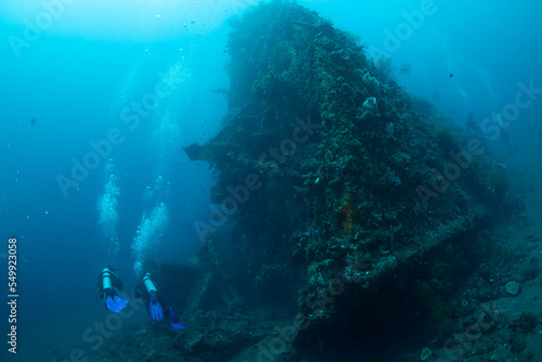 Scuba divers in the sea next to the ship wreck
