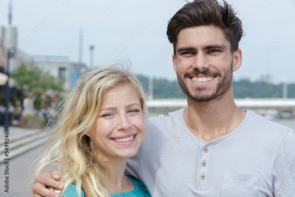 young couple smiling and posing for picture young couple smiling and posing for picture