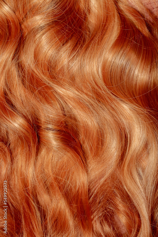 Red hair close-up as a background. Women's long orange hair. Beautifully styled wavy shiny curls. Hair coloring bright shades. Hairdressing procedures, extension. Red hair close-up as a background. Women's long orange hair. Beautifully styled wavy shiny curls. Hair coloring bright shades. Hairdressing procedures, extension.
