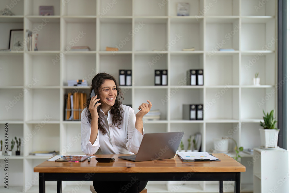 Business woman using laptop and talking on mobile phone Business woman using laptop and talking on mobile phone