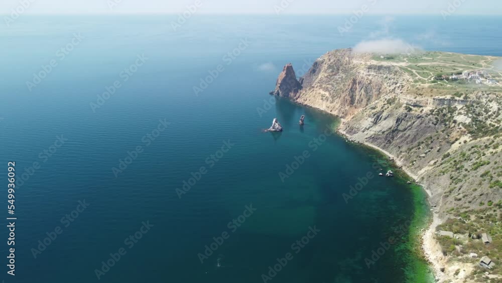 Aerial view from above on calm azure sea and volcanic rocky shores. Small waves on water surface in motion blur. Nature summer ocean sea beach background. Nobody. Holiday, vacation and travel concept Aerial view from above on calm azure sea and volcanic rocky shores. Small waves on water surface in motion blur. Nature summer ocean sea beach background. Nobody. Holiday, vacation and travel concept