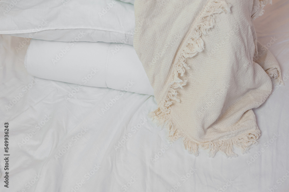 Obraz premium stack of white pillows and blankets lies on the bed on a white sheet on top, covered with a blanket