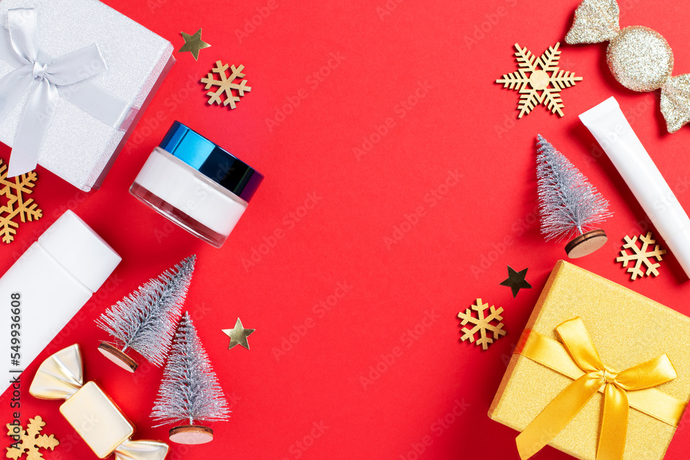 Fototapeta premium Cosmetic products, gift box and Christmas decoration and baubles on bright red background.