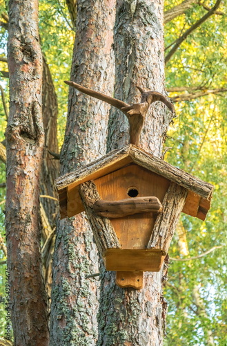 Fotobehang Wooden birdhouse on a tree in the spring forest