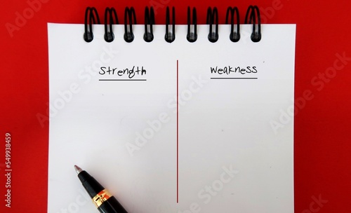 Pen on note book with text written STRENGTH and WEAKNESS - concept of making personal defined lists of strong and weak points for a job interview or self improvement photo