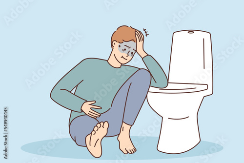 Unhealthy man suffer from intoxication near toilet