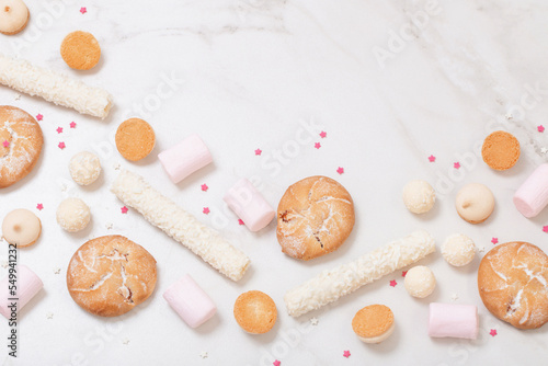candies and cookies on white marble background