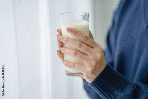 Woman holding a glass of milk.