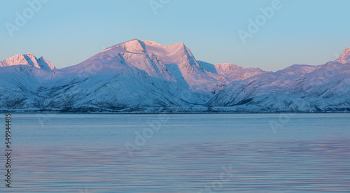 Panoramic view at fjord with coast of the Norwegian Sea  snowy mountains in the background   Arctic Circle at sunset - Norway