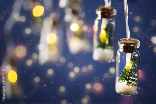 Creative Christmas garland lights with bokeh. Christmas tree in a glass jar with snow. Christmas greeting card.