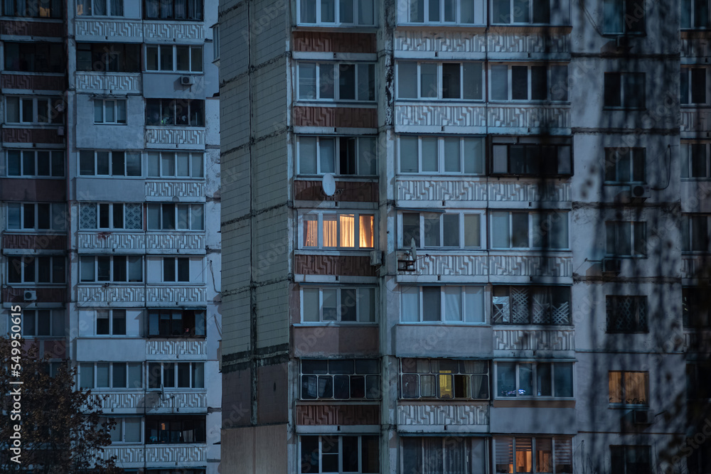 Light in one window in apartment multistorey building during the rolling blackout of electricity in a residential area of Kyiv after russian shelling of power plants.