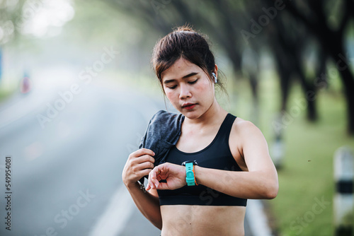 asian Fitness woman setting up smart watch before running training during morning workout,female checking heartrate and pulse from smart watch monitor after running fininsh healthy lifestyle concept photo