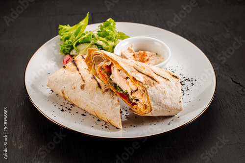 Tasty dish of pita with meat and vegetables on wooden background