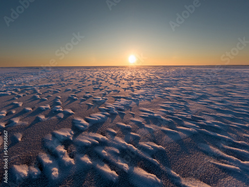 The surface of a frozen lake. Sunset in winter.