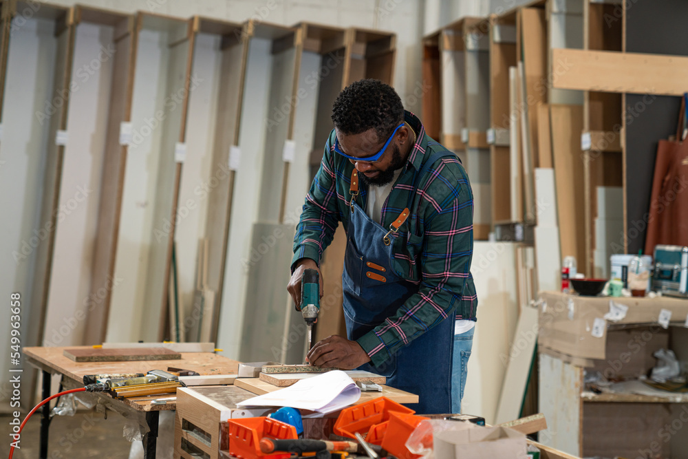 Afro american craftsman working as carpenter in a carpentry workshop, Small family business concept of young entrepreneurs. Afro american craftsman working as carpenter in a carpentry workshop, Small family business concept of young entrepreneurs.