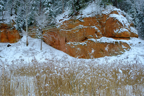 Sandstone rock. Zvartes rocks on the banks of the Amata River, on a white, snowy and cold winter day, Gauja National Park, Latvia photo