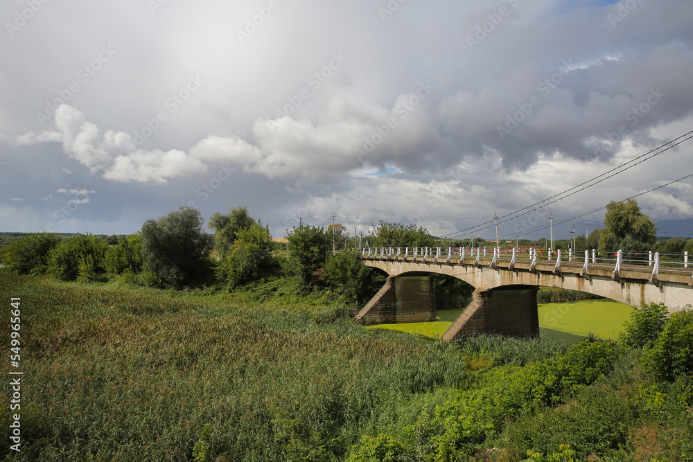 the old bridge over the river with blooming green water, the bridge was built in 1910