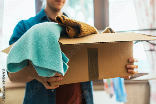 Man holding box with clothes, concept of clothes donation photo