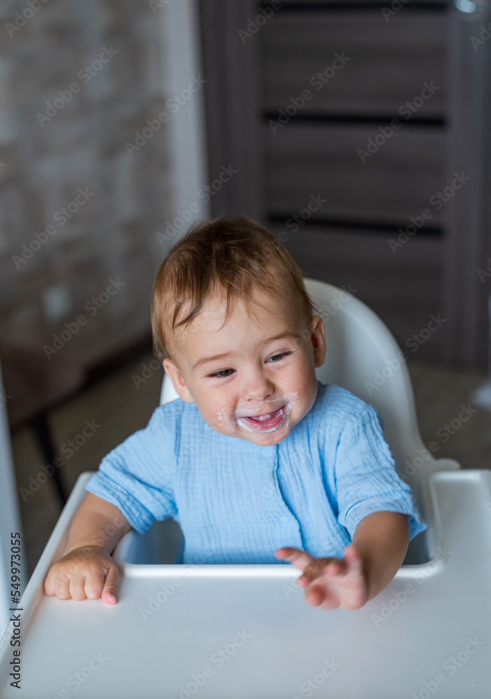 Baby eating at kitchen empty space table. Child's nutrition. Baby eating at kitchen empty space table. Child's nutrition.