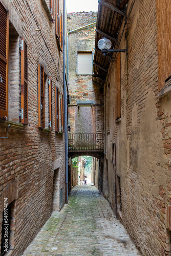 View of Monbaroccio, a little fortified village in the Province of Pesaro e Urbino in the Italian region Marche. A narrow street with an arch. photo