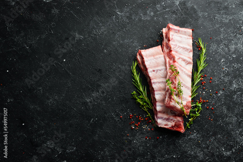 Tela Meat. Raw Pork ribs with rosemary. Top view. Rustic style.