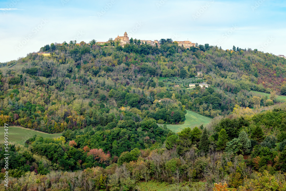 Autumn view of fields  and woods under Belvedere Fogliense, Region Marche of Italy. In the background appears the medieval city of Mondaino