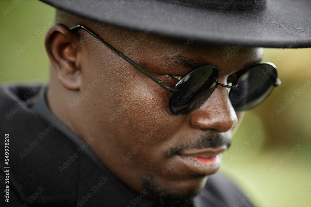 Close up of African American man wearing black hat with sunglasses Close up of African American man wearing black hat with sunglasses