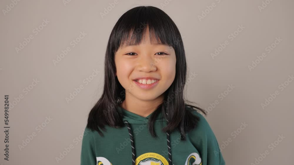 Little asian teen girl smiles at the camera. Dolly in. Little asian teen girl smiles at the camera. Dolly in.