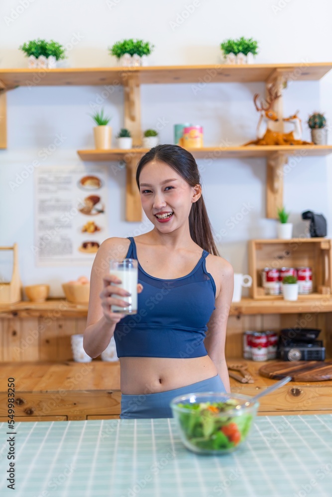 Young asian female adult drinking milk for fitness and healthy. Beautiful lady in blue color gym exercise outfit. Young asian female adult drinking milk for fitness and healthy. Beautiful lady in blue color gym exercise outfit.