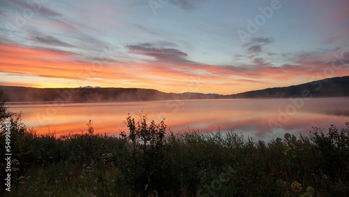 Scenic view of fog covering a lake during the sunrise