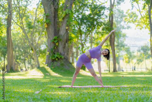 Fitness woman doing yoga in park, calm and relaxing women's happiness blurry background Asian woman meditating while practicing yoga concept of freedom peace and relaxation healthy