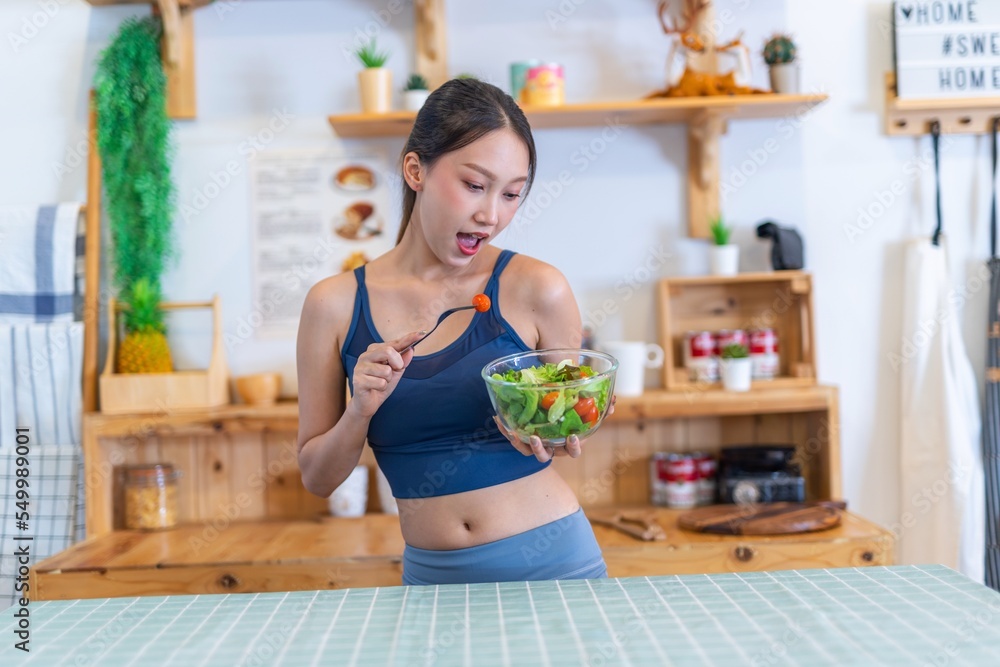 Young beautiful asian female adult lady in gym outfit after yoga exercise. Eat clean food salad with tomato for healthy and slim fit lifestyle. Young beautiful asian female adult lady in gym outfit after yoga exercise. Eat clean food salad with tomato for healthy and slim fit lifestyle.
