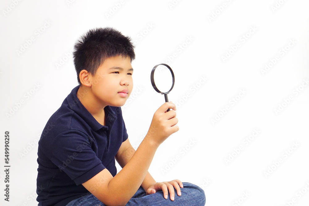 Boy holding a magnifying glass on white background. Knowledge, research and explore concept. Boy holding a magnifying glass on white background. Knowledge, research and explore concept.