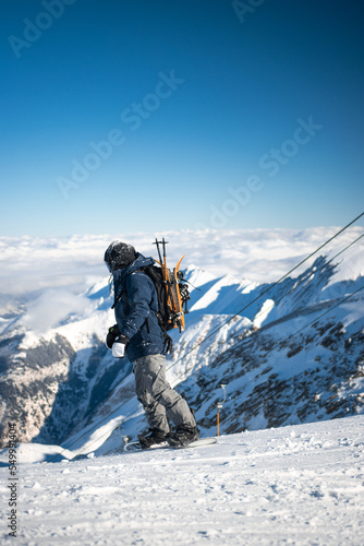 Male snowboarder on top of mountain in Austria with equipment. High quality image of snowboarding man on snowy mountain.