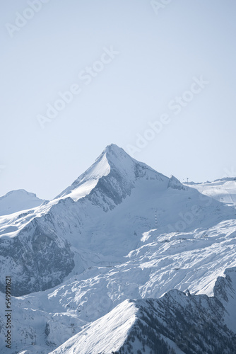 High quality landscape photo of Austrian mountain range with blue sky. Image of mountain peak covered in snow.