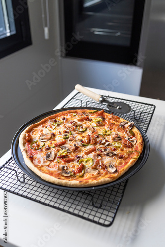 Vegetable and ham pizza freshly made in the home oven. Healthy food concept. Cook at home.