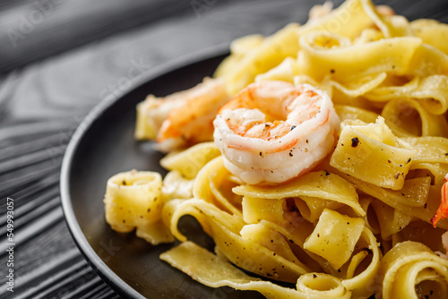delicious shrimp fettuccine alfredo pasta on a black rustic background