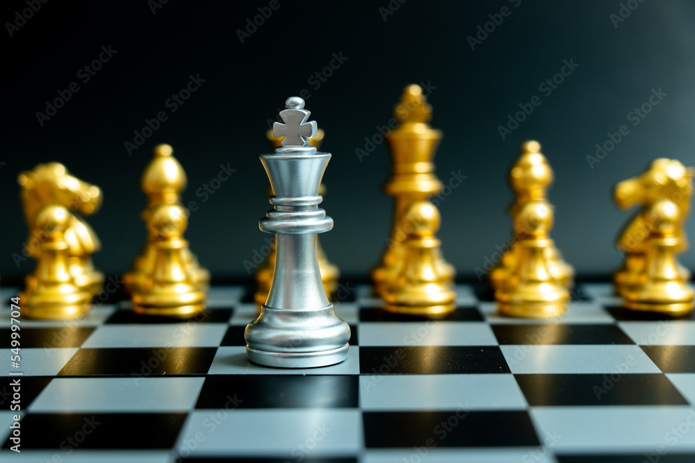 Silver king chess piece face another gold team on black background (Concept for leadership, problem or crisis situation) Silver king chess piece face another gold team on black background (Concept for leadership, problem or crisis situation)