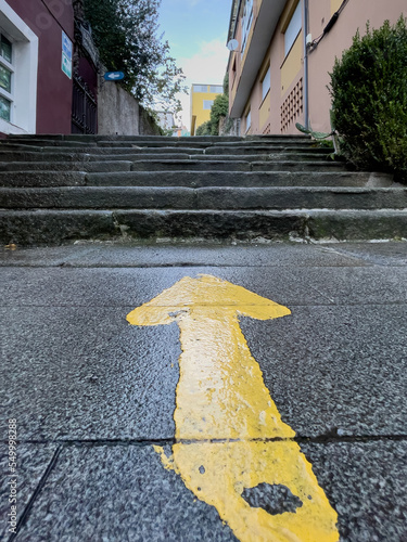 Traditional symbol of yellow arrow on the french way of santiago. Orientation sign for pilgrims in Sarria. Pilgrimage route to the apostle Santiago. photo