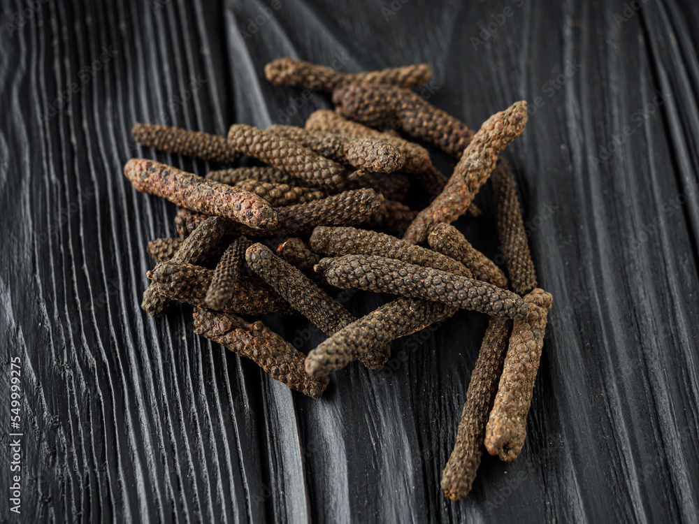 dried aromatic pippali long pepper on black wooden rustic background