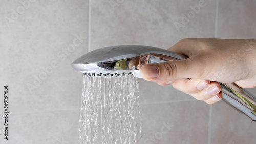 The girl in her hand holds a shower head with water mode switches.