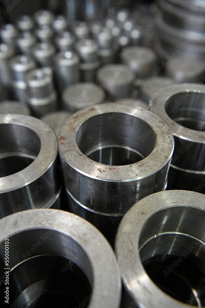 A pile of round metal parts. A large number of accumulated steel parts in the machine workshop.