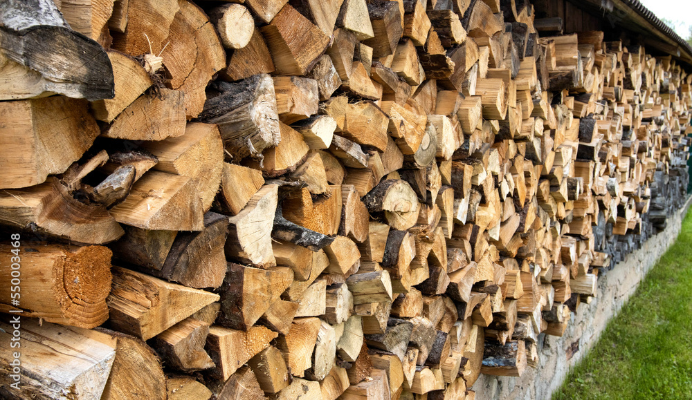 Shed for storing firewood in the village. Wood for heating. Copy space for text, firewood wall Shed for storing firewood in the village. Wood for heating. Copy space for text, firewood wall
