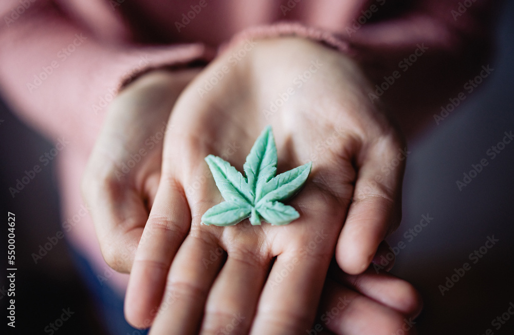 Cbd edible - Woman holding cannabis candy leaf for anxiety treatment - Marijuana alternative medicine Cbd edible - Woman holding cannabis candy leaf for anxiety treatment - Marijuana alternative medicine